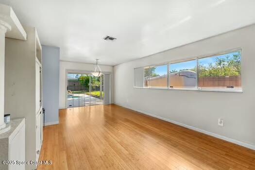 933 Waialae Circle Northeast Palm Bay, FL 32905 - Photo 19 of 32 a view of an empty room with wooden floor and a window