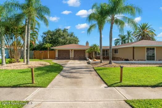 933 Waialae Circle Northeast Palm Bay, FL 32905 - Photo 2 of 32 a view of a house with a yard and palm trees