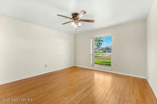 933 Waialae Circle Northeast Palm Bay, FL 32905 - Photo 21 of 32 a view of an empty room with a window and wooden floor