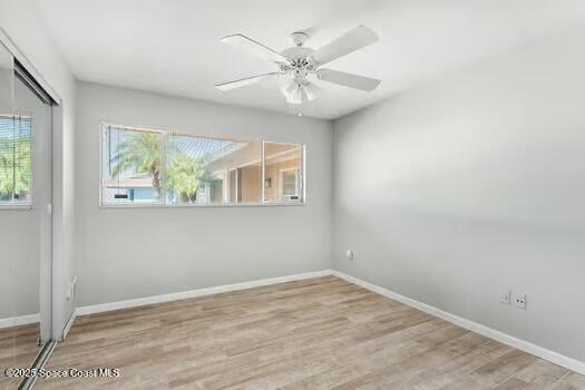 933 Waialae Circle Northeast Palm Bay, FL 32905 - Photo 24 of 32 an empty room with wooden floor fan and windows