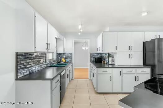 933 Waialae Circle Northeast Palm Bay, FL 32905 - Photo 10 of 32 a kitchen with stainless steel appliances a sink a stove and a refrigerator with white cabinets
