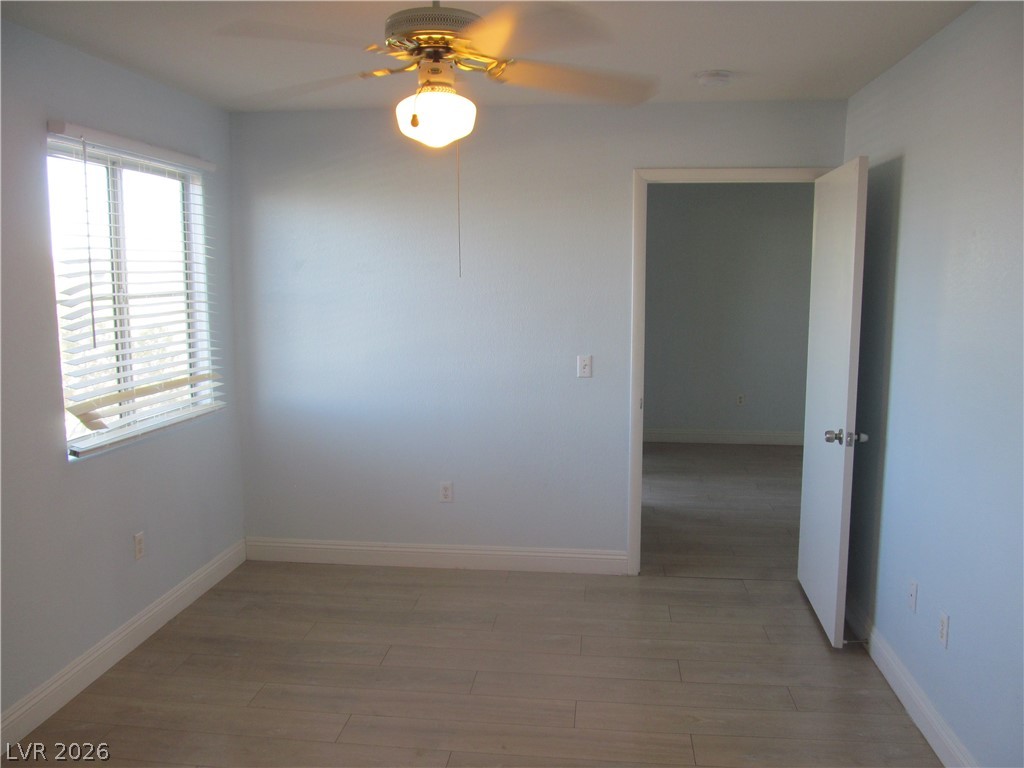 7950 West Flamingo Road, Unit 2048 Las Vegas, NV 89147 - Photo 17 of 24 A quiet room featuring wood flooring and a classic ceiling fan, offering a cozy retreat.