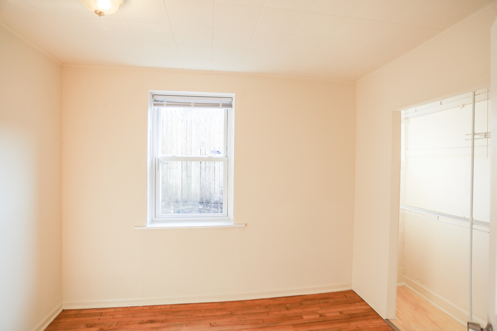 2315 West School Street, Unit G Chicago, IL 60618 - Photo 11 of 12 a view of an empty room with wooden floor and a window