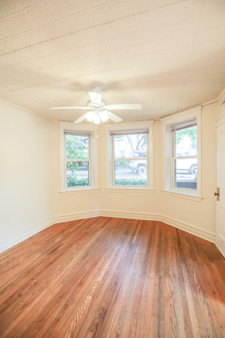2315 West School Street, Unit G Chicago, IL 60618 - Photo 2 of 12 an empty room with wooden floor and windows