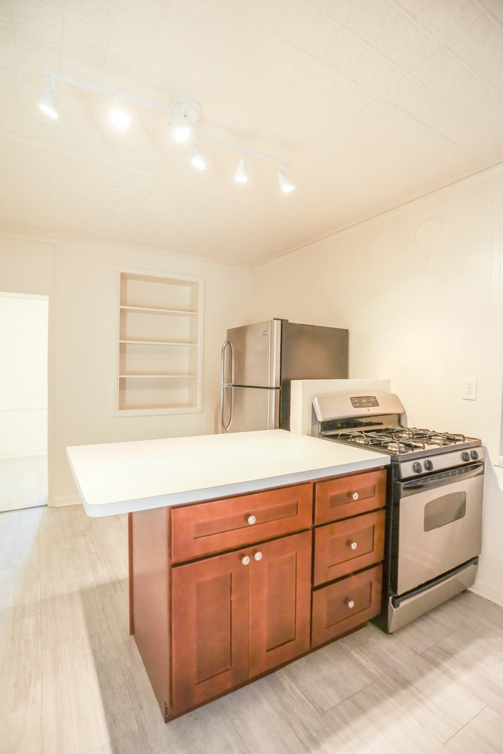 2315 West School Street, Unit G Chicago, IL 60618 - Photo 6 of 12 a kitchen with stainless steel appliances granite countertop a stove a sink and a refrigerator