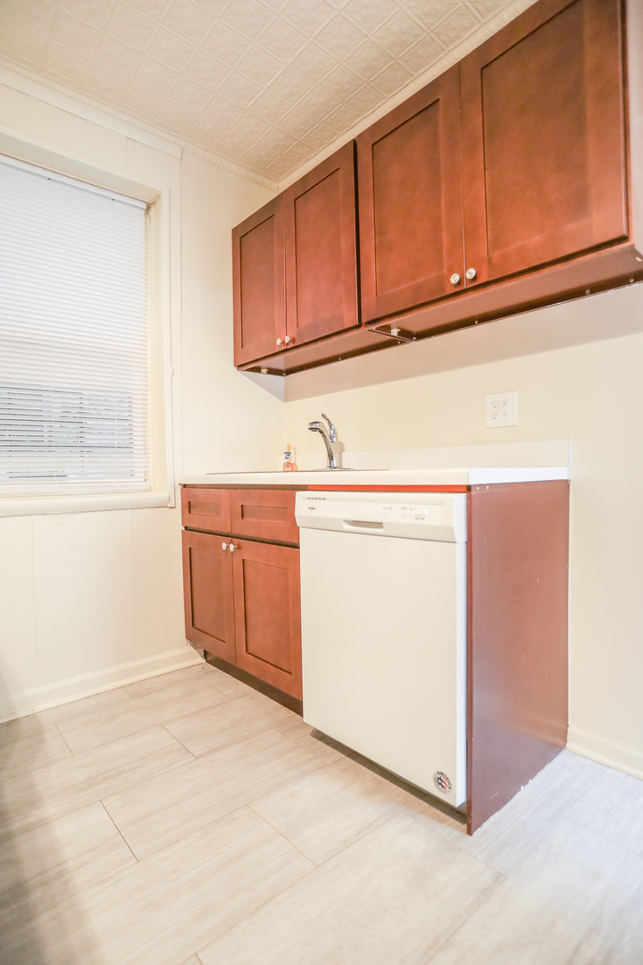 2315 West School Street, Unit G Chicago, IL 60618 - Photo 7 of 12 a utility room with granite countertop cabinets washer and dryer