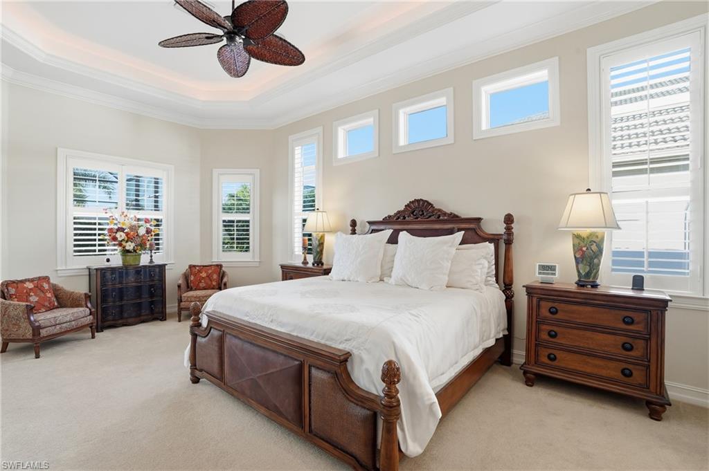 430 Saddlebrook Lane Naples, FL 34110 - Photo 14 of 37 a spacious bedroom with a bed and a chandelier