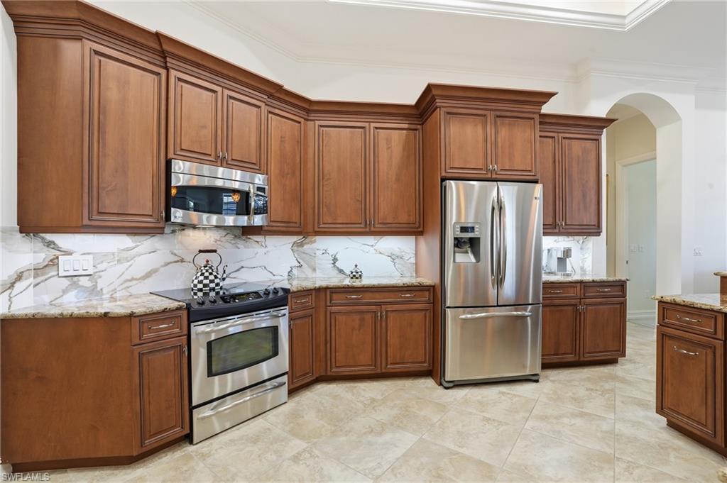 430 Saddlebrook Lane Naples, FL 34110 - Photo 8 of 37 a kitchen with stainless steel appliances granite countertop a refrigerator stove a sink and a microwave