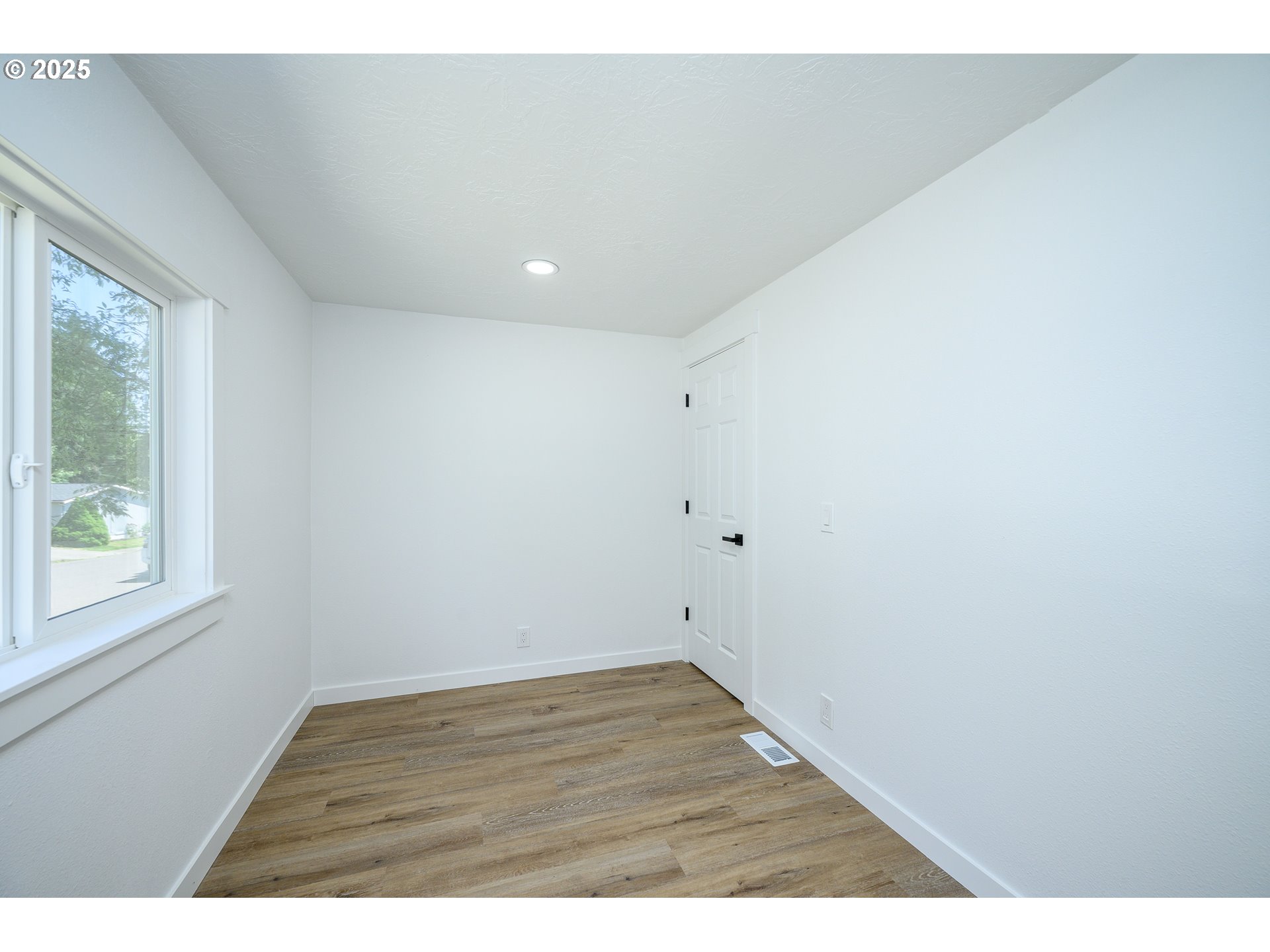 13620 Southwest Beef Bend Road, Unit 38 Portland, OR 97224 - Photo 19 of 38 a view of an empty room with wooden floor and a window