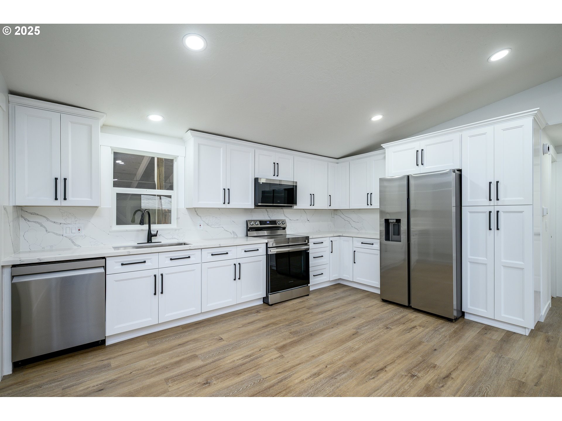 13620 Southwest Beef Bend Road, Unit 38 Portland, OR 97224 - Photo 6 of 38 a kitchen with stainless steel appliances white cabinets a sink a stove a refrigerator and a microwave