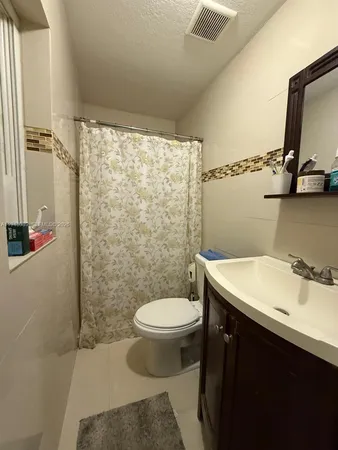 a bathroom with a sink toilet and a mirror