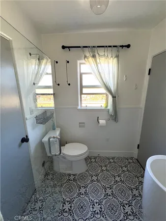 a bedroom with a bed and a flat tv screen on dresser