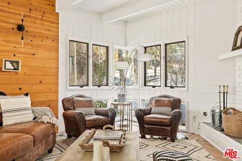 a living room with furniture a fireplace and a large window