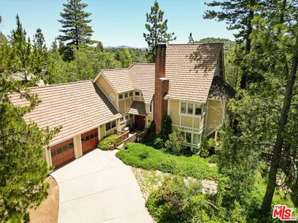 a aerial view of a house with a yard and trees
