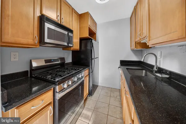 a kitchen with stainless steel appliances granite countertop a stove and a microwave