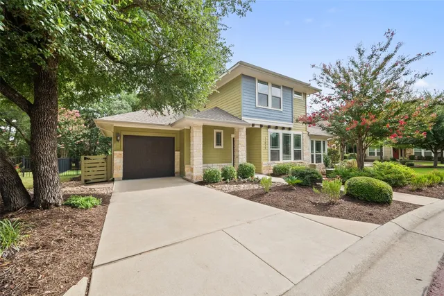 a front view of a house with a yard and potted plants