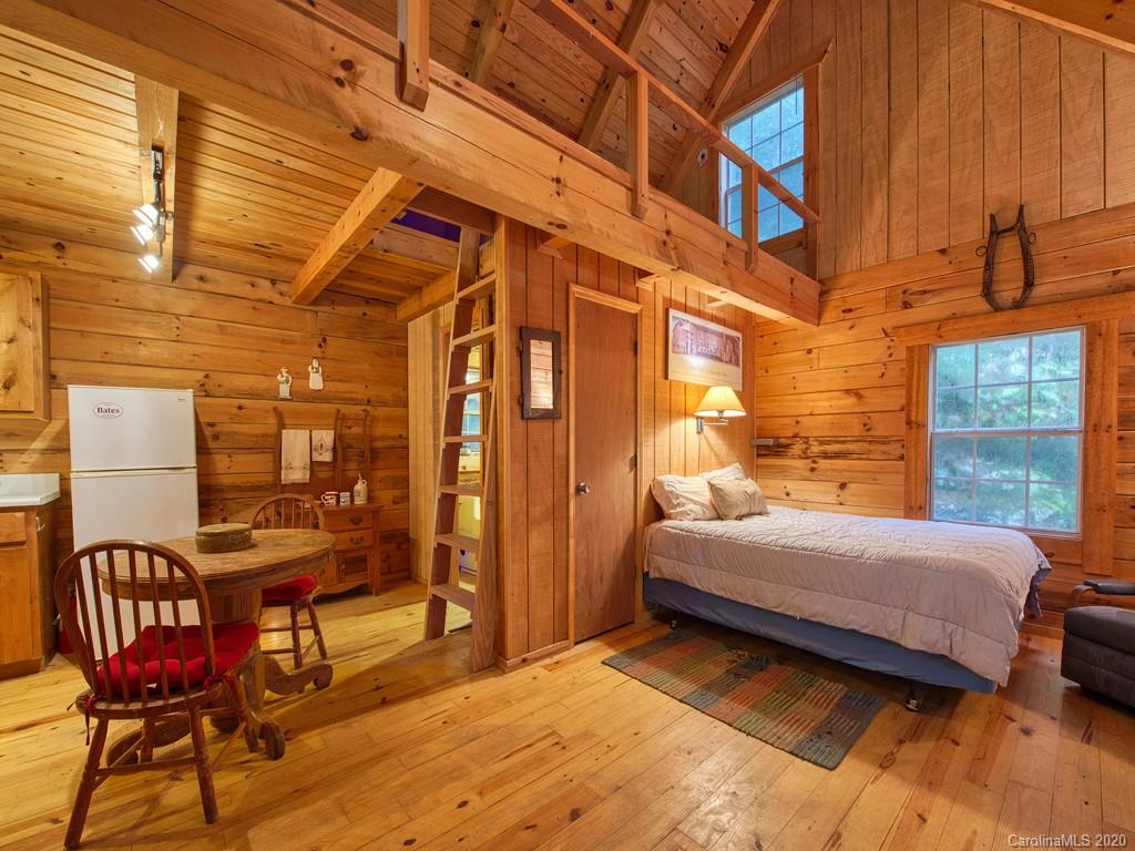 784 Flat Branch Road Waynesville, NC 28785 - Photo 14 of 25 a bedroom with a bed and glass windows