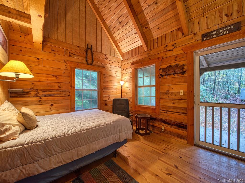784 Flat Branch Road Waynesville, NC 28785 - Photo 15 of 25 a bedroom with a bed and wooden floor