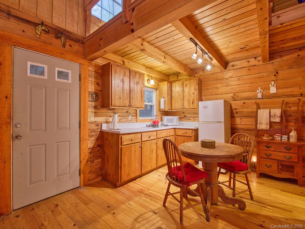 784 Flat Branch Road Waynesville, NC 28785 - Photo 10 of 25 a kitchen with stainless steel appliances kitchen island granite countertop a table chairs and a refrigerator