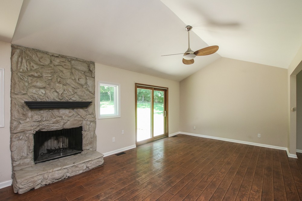 590 Weeping Elm Road Mount Juliet, TN 37122 - Photo 7 of 20 a view of an empty room with wooden floor a fireplace and a window