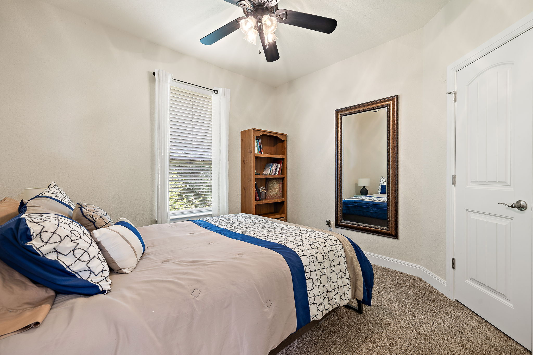 6708 Menchaca Road, Unit 10 Austin, TX 78745 - Photo 20 of 28 Carpeted room featuring a ceiling fan with integrated lighting, a window with blinds, and a white paneled door with brushed nickel hardware