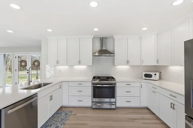 a kitchen with stainless steel appliances kitchen island granite countertop a refrigerator and cabinets