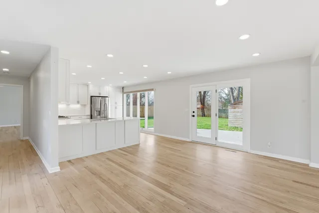 a view of empty room with wooden floor and fireplace