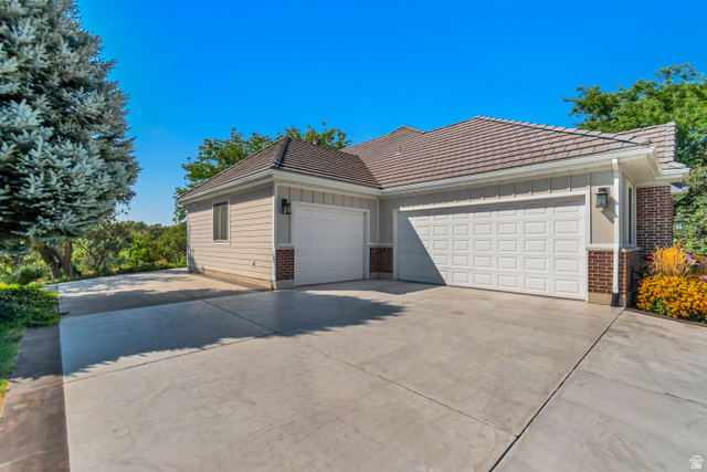 1567 Ridgeview Circle Farmington, UT 84025 - Photo 4 of 55 Exterior featuring tan siding, brick accents, concrete driveway, and a multi-car garage with white panel doors