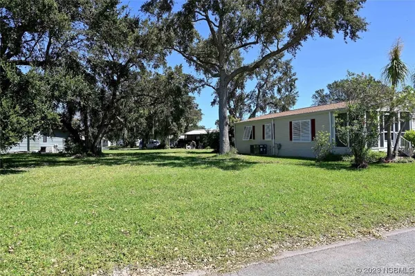 a view of a house with backyard and trees