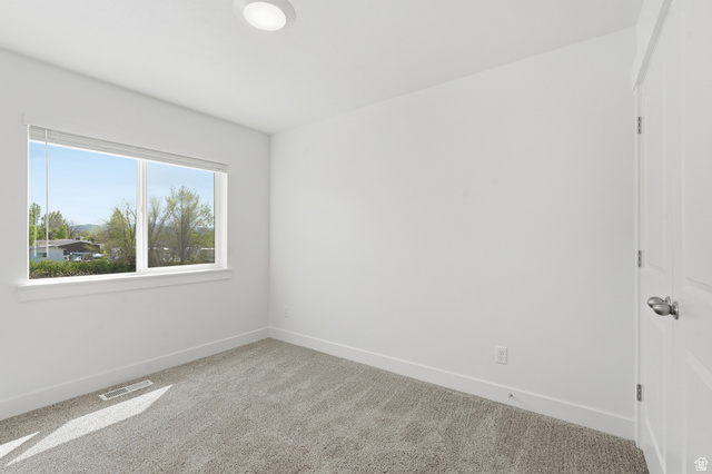 1173 West 1870 South Logan, UT 84321 - Photo 14 of 33 Neutral-toned room featuring a large window, light gray carpeting, crisp white walls, and a recessed ceiling light fixture