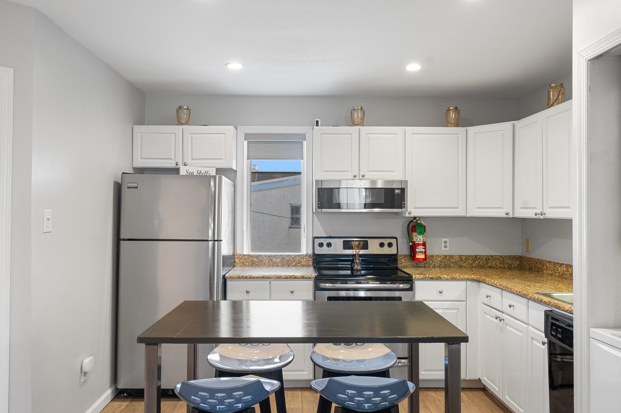 177 80th Street, Unit 304 Avalon, NJ 08202 - Photo 1 of 31 a kitchen with kitchen island a table and chairs in it