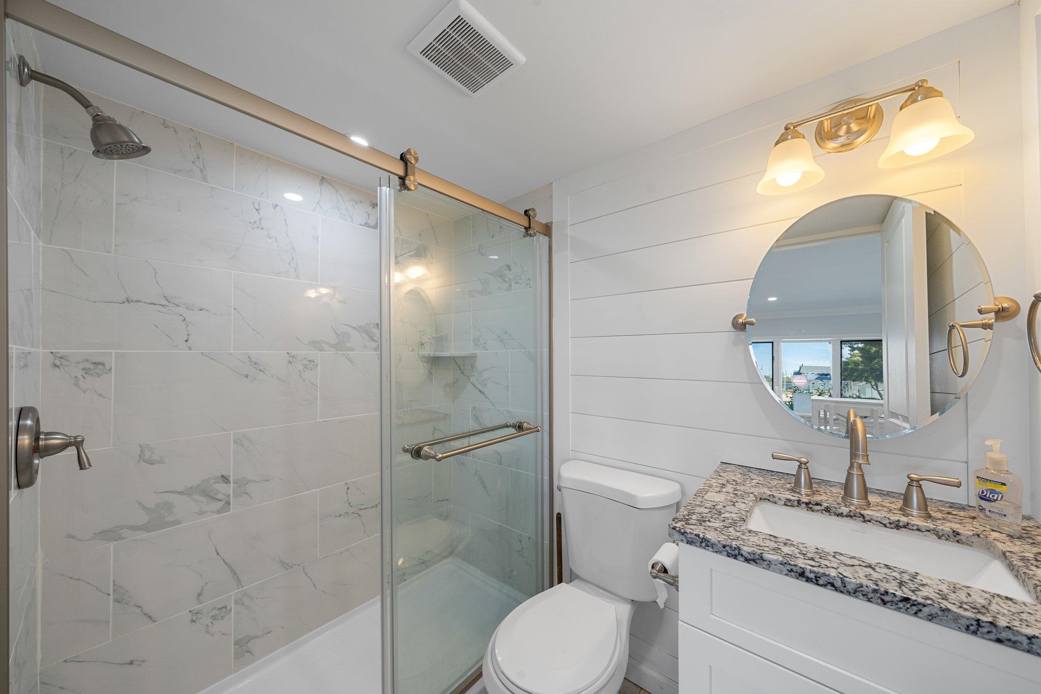 177 80th Street, Unit 304 Avalon, NJ 08202 - Photo 14 of 31 a bathroom with a granite countertop sink toilet a mirror and shower
