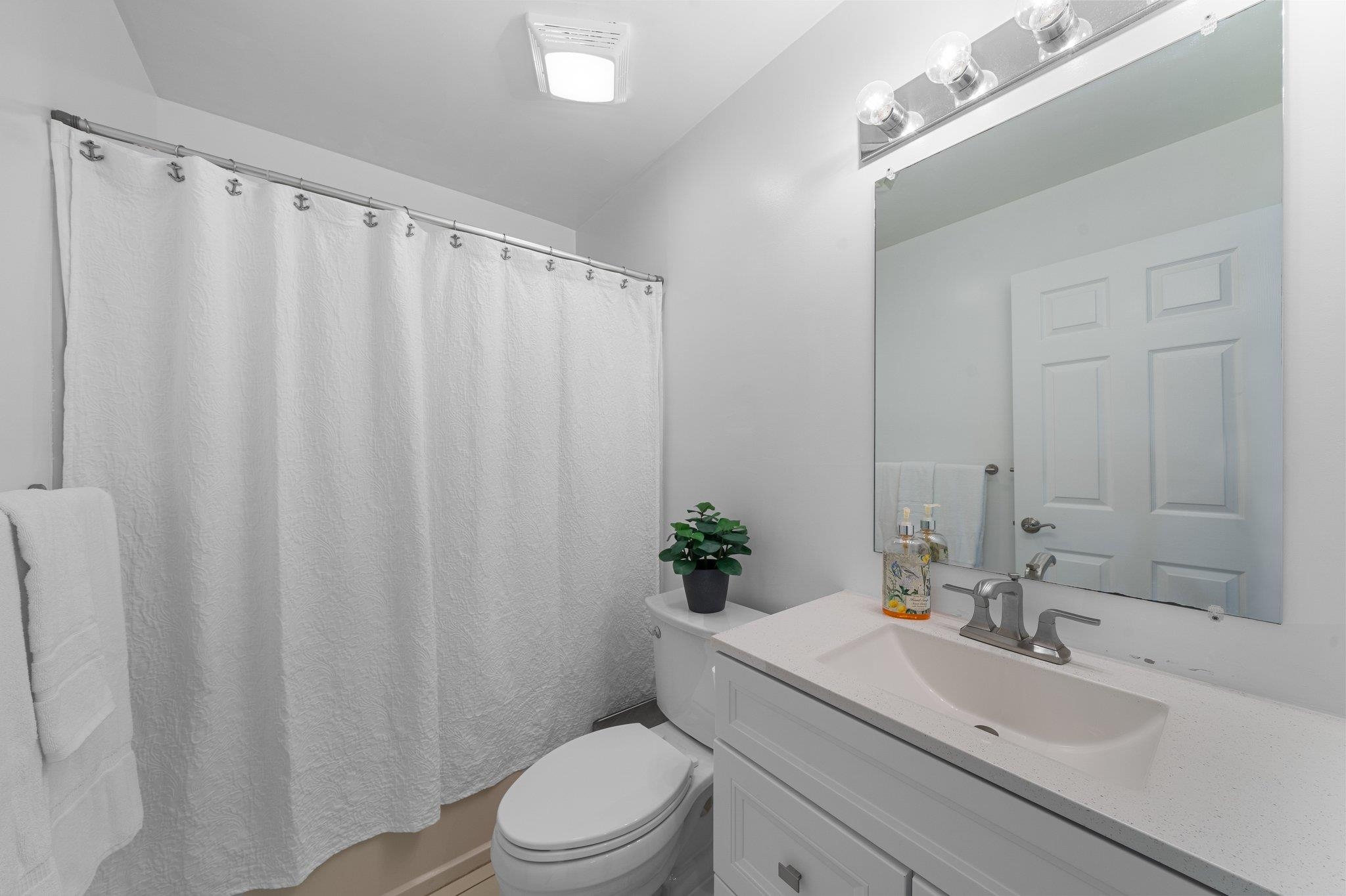 177 80th Street, Unit 304 Avalon, NJ 08202 - Photo 5 of 31 a bathroom with a sink a toilet and shower curtain