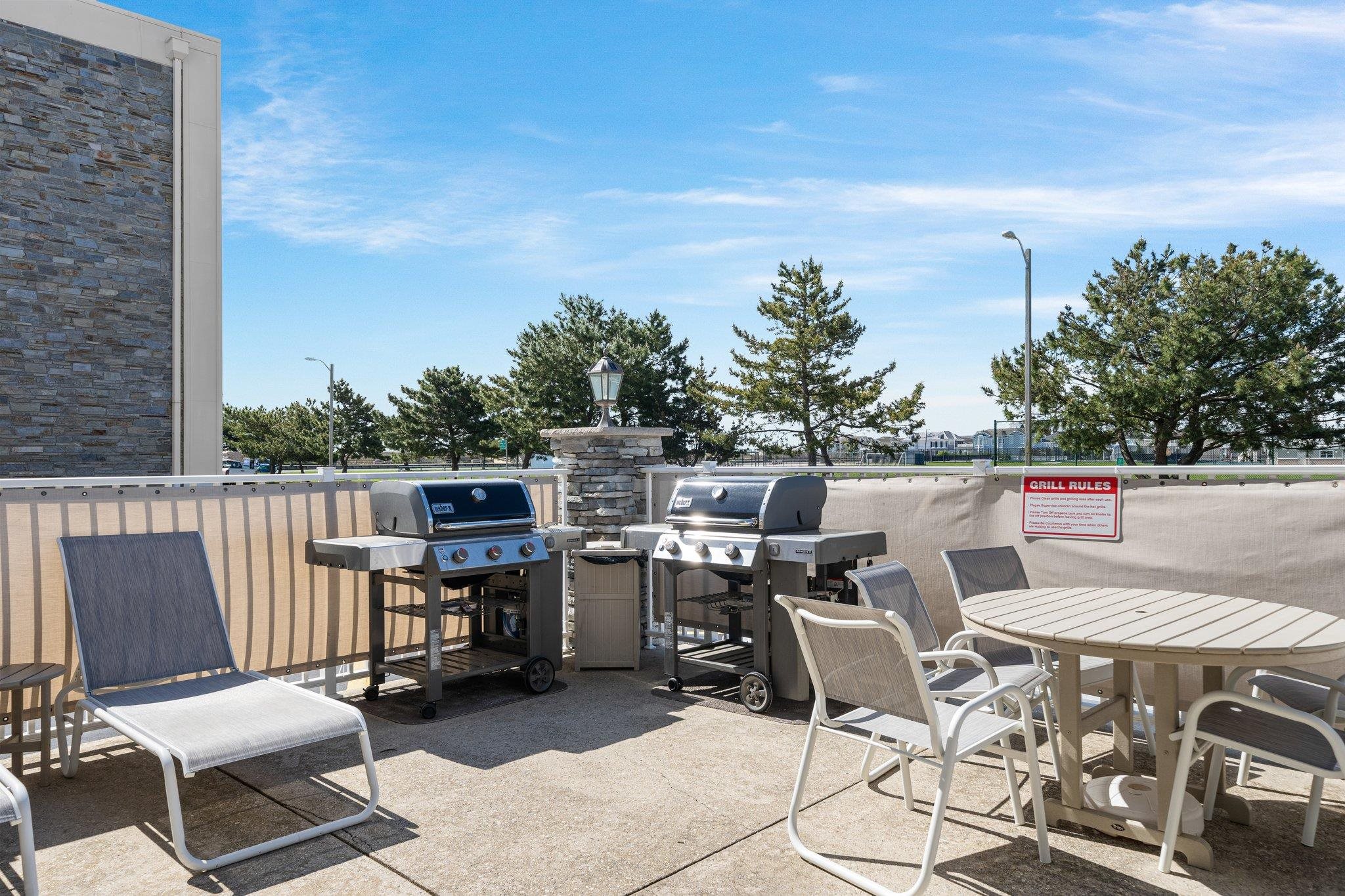 177 80th Street, Unit 304 Avalon, NJ 08202 - Photo 10 of 31 a roof deck with table and chairs a barbeque with wooden floor and fence