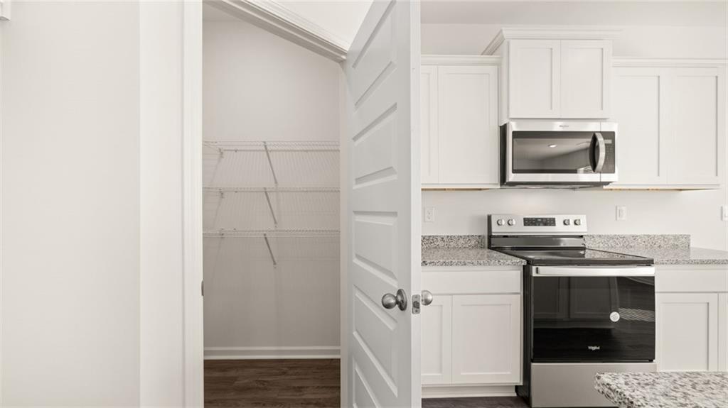 73 White Spruce Way Newnan, GA 30265 - Photo 11 of 47 a kitchen with stainless steel appliances granite countertop a stove and a microwave