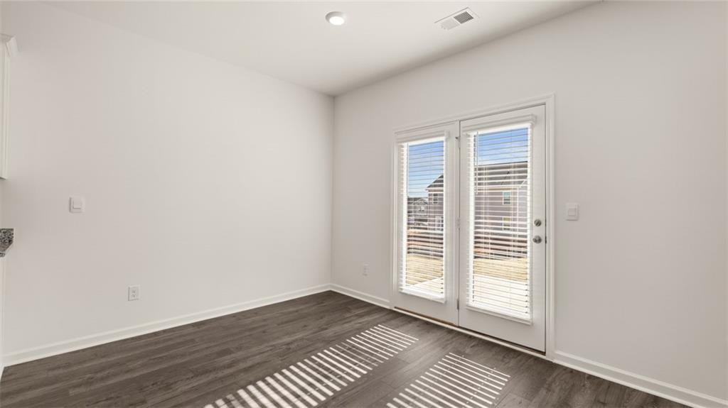 73 White Spruce Way Newnan, GA 30265 - Photo 12 of 47 an empty room with wooden floor and windows