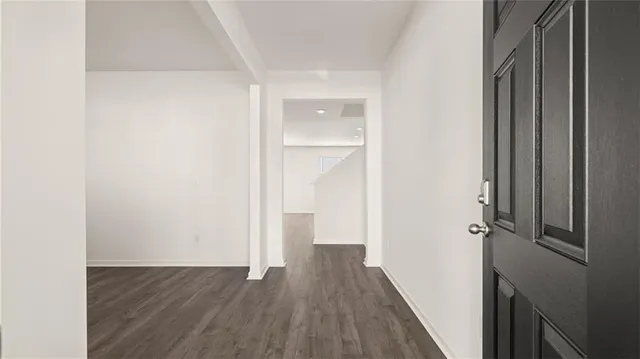 a view of a hallway with wooden floor and closet