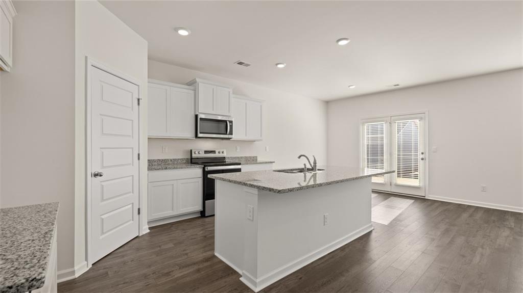 73 White Spruce Way Newnan, GA 30265 - Photo 6 of 47 a kitchen with stainless steel appliances granite countertop a sink stove and refrigerator
