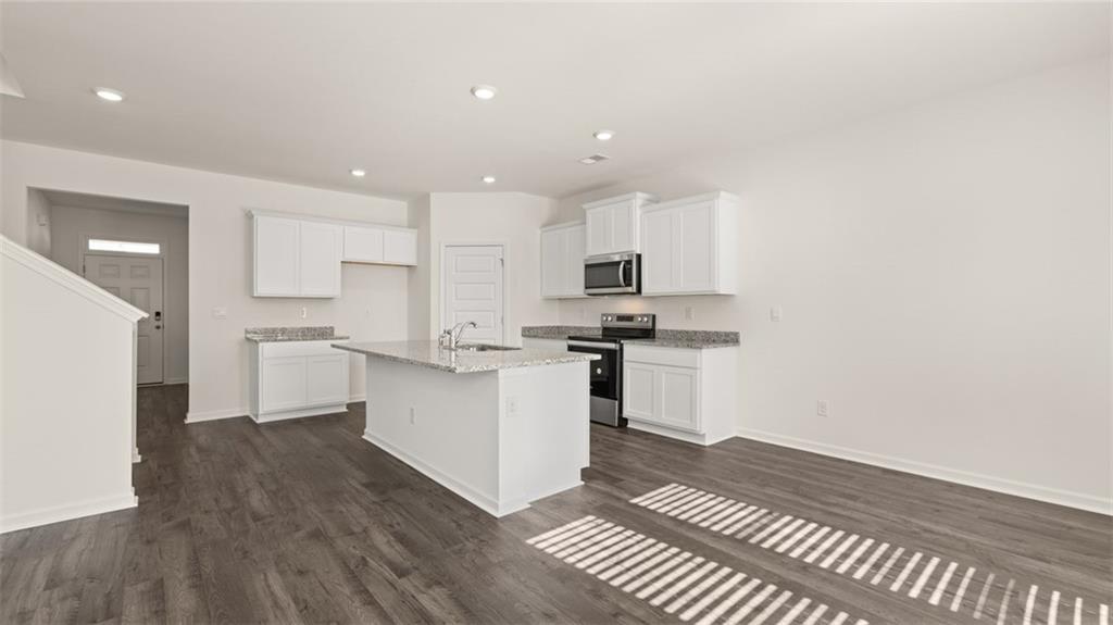 73 White Spruce Way Newnan, GA 30265 - Photo 8 of 47 a kitchen with a refrigerator and white cabinets