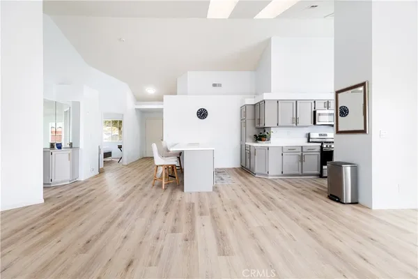 a living room with stainless steel appliances kitchen island furniture and wooden floor