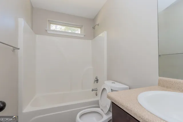 a bath room with a toilet a sink and a bath tub