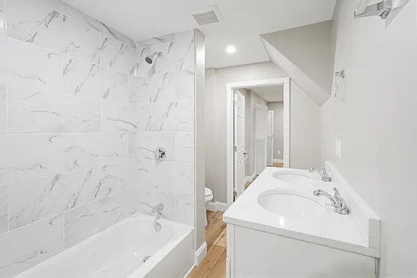 a bathroom with a sink a toilet and shower