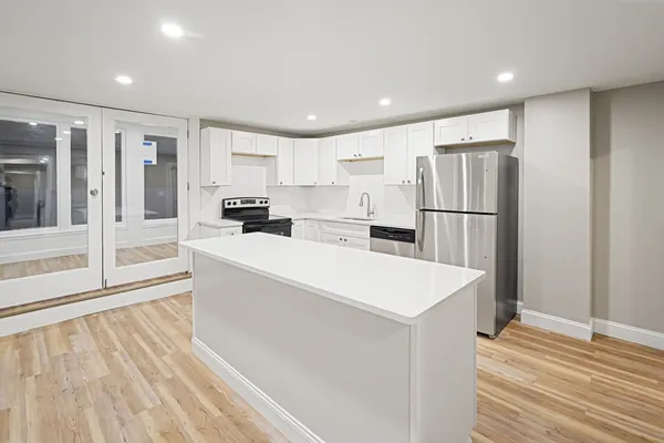 a large white kitchen with wooden floor and floors