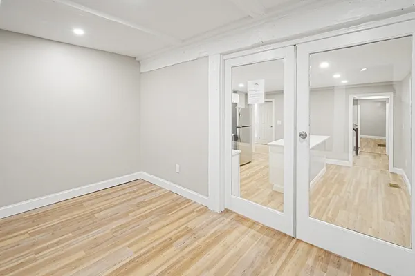 an empty room with wooden floor and a bathroom