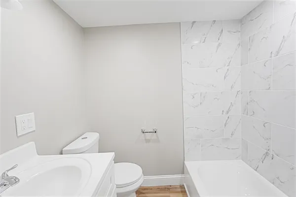 a white toilet sitting next to a bath tub