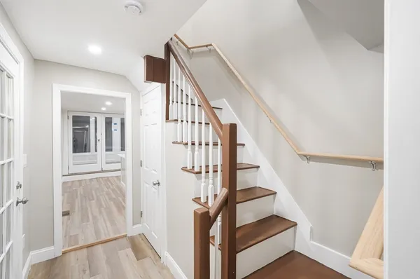 a view of staircase with wooden floor and white walls
