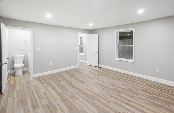 a view of a room with wooden floor and toilet