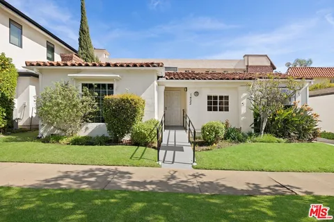 a front view of a house with a garden and yard