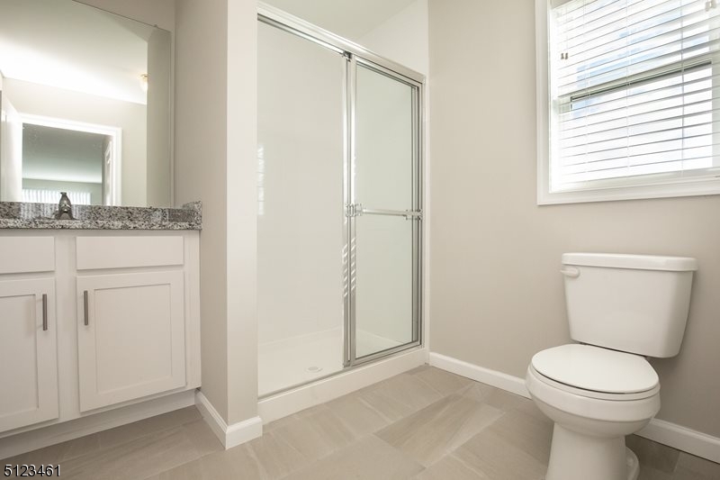 96 Arlene Court Morris Plains, NJ 07950 - Photo 21 of 24 a bathroom with a granite countertop toilet a sink and a mirror