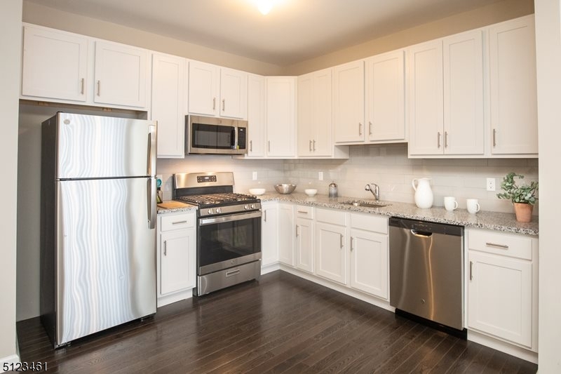 96 Arlene Court Morris Plains, NJ 07950 - Photo 3 of 24 a kitchen with granite countertop white cabinets and stainless steel appliances